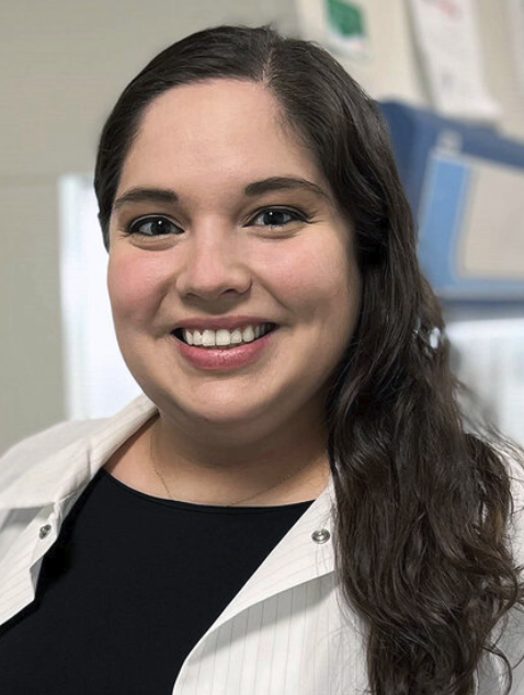 A brunette woman wearing a lab coat