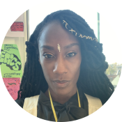 Fabiene Monde, a black woman with long dreads and a gold bindi on her forehead