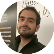 A brunette man with a beard, smiing